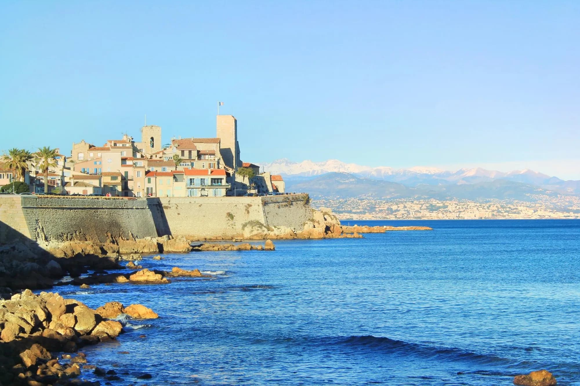 Vue de la vieille ville d'Antibes avec le Fort Carré et les Alpes en arrière-plan